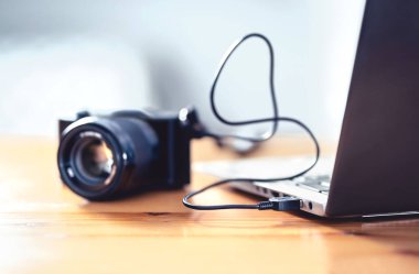 Kamera USB kablosuyla dizüstü bilgisayara bağlı. DSLR 'dan bilgisayara dosya transferi. Fotoğraf için yedekleme deposu.