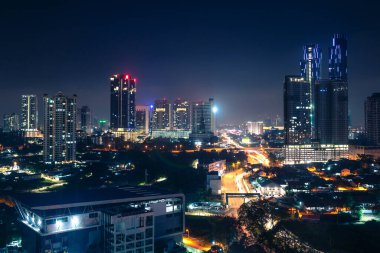 Johor Bahru, Malezya, gece. Şehir merkezinde trafik, modern iş binaları ve oteller bulunan Malezya şehri. Manzaralı şehir silueti ve şehir manzarası. Hava görünümü.