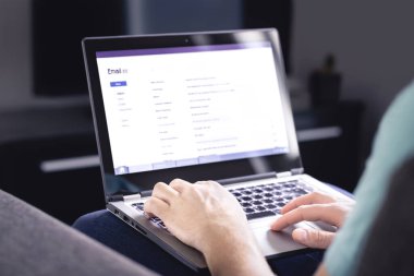 E- posta kutusu dizüstü bilgisayar ekranında. Mesajların listesi. Adam gelen e-postayı kontrol ediyor. Spam, ıvır zıvır ve dijital pazarlama. Okuyun, cevaplayın ya da iletin. Evde bilgisayarla çalışan biri. Mockup web sayfası.