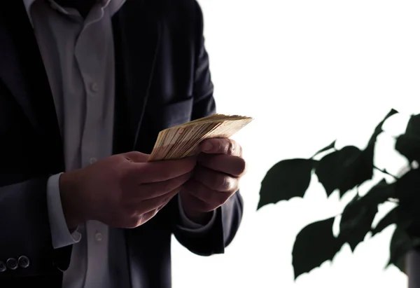 Environment or eco business and finance. Invest to sustainable and green energy. Man in a suit counting money. Plant with leafs. Environmental lawyer, attorney or investor. Investment in ecology.