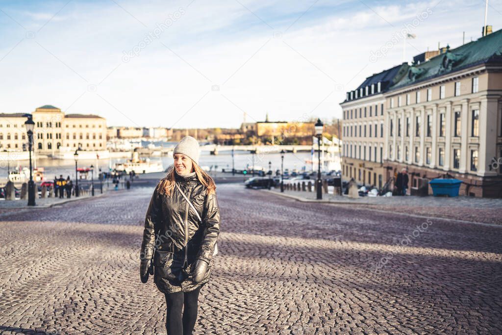 Stockholm in winter. Person walking in urban city street in Sweden. Happy tourist looking at buildings in the old town. Woman in Gamla Stan. Tourism and vacation in Scandinavia. Travel lifestyle.