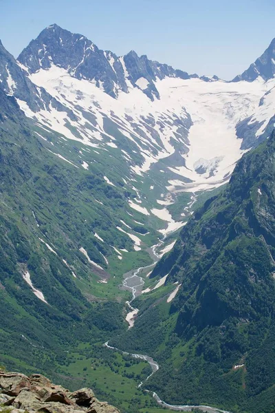 Yaz dağı manzarası. Yüksek dağlar ve dağların üstünde parlak mavi bir gökyüzü