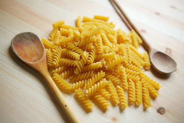 Na superfície de madeira colocar um macarrão molhado em forma de espiral — Fotografia de Stock