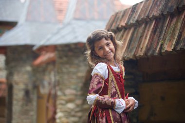 Ortaçağ kırmızı elbiseli küçük bir kız eski şatonun yanında taş ustası..