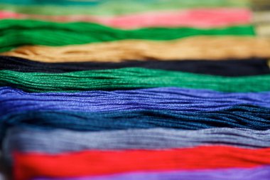 İşleme ve yaratıcılık için farklı renk ve tonların ipliklerine yakın çekim. Hobi ve el işi kavramı..