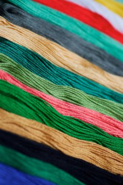 İşleme ve yaratıcılık için farklı renk ve tonların ipliklerine yakın çekim. Hobi ve el işi kavramı..