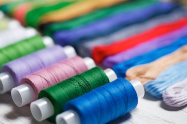 Dikiş dikmek, nakış işlemek ve yaratıcılık için farklı renk ve tonlardaki bobinleri kapat. Hobi ve el işi kavramı..