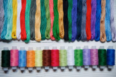 Dikiş dikmek, nakış işlemek ve yaratıcılık için farklı renk ve tonlardaki bobinleri kapat. Yukarıdan manzara. Hobi ve el işi kavramı..