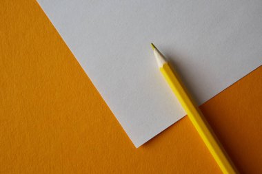 Sarı renkli kalem parlak sarı ve beyaz arkaplanda yatıyor, makro fotoğraf..