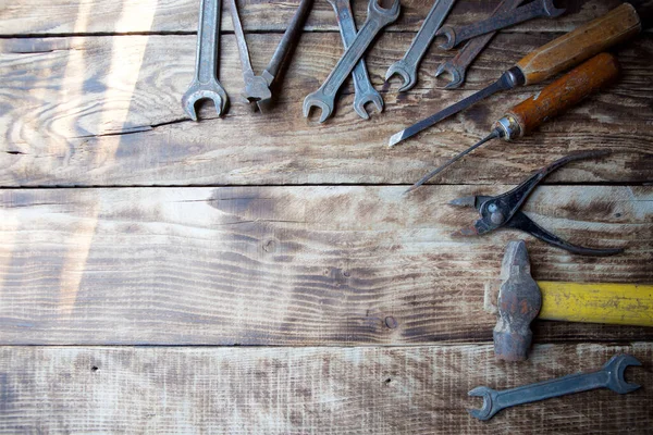 Ahşap bir yüzey üzerinde çalışan eski tip metal işçiliği ve tamir aletleri..