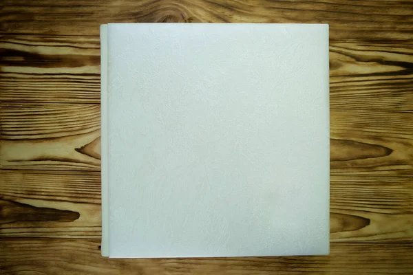 Auf Der Holzoberfläche Liegt Ein Geschlossenes Buch Mit Weißem Ledereinband — Stockfoto
