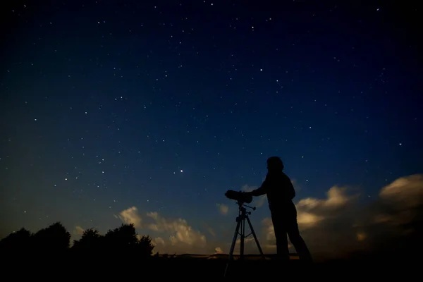 星空や銀河を研究する望遠鏡を持つ大人の男のシルエット 夜の自然景観を背景に天文台のある男が立っている — ストック写真