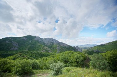 Yaz dağı manzarası. Yüksek dağlar ve dağların üstünde parlak mavi bir gökyüzü