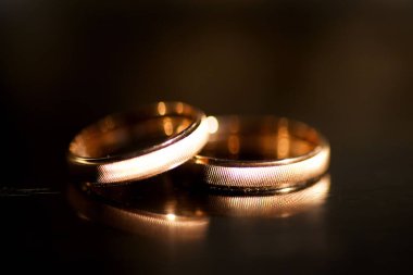 Nikah yüzükleri, ayna yansıtan bir yüzeyde bulunur. Tatiller ve nişanın onuruna kutlamalar.