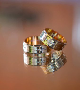 Nikah yüzükleri, ayna yansıtan bir yüzeyde bulunur. Tatiller ve nişanın onuruna kutlamalar.