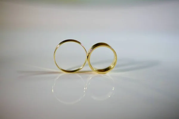 結婚式のための結婚指輪は表面を反映する鏡の上にある 婚約を記念して休日やお祝い — ストック写真