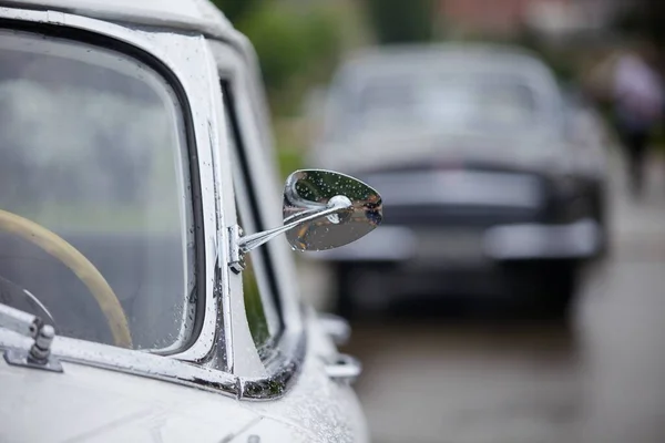 Mirror old vintage car in rain drops.