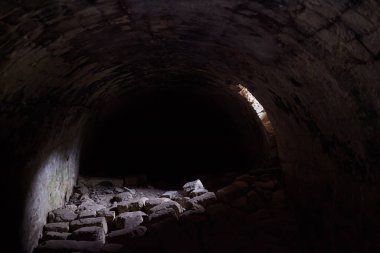 Kalenin altındaki antik taş zindan ya da orta çağdan kalma eski bir bina. Eski duvarlar ve delici ışıkla açılan açıklıklar.