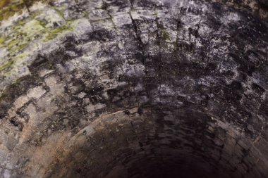 Kalenin altındaki antik taş zindan ya da orta çağdan kalma eski bir bina. Eski duvarlar ve delici ışıkla açılan açıklıklar.