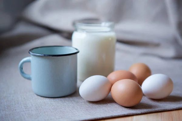 Değişik türde ev yapımı tavuk yumurtaları ve bir kavanoz taze inek sütü..