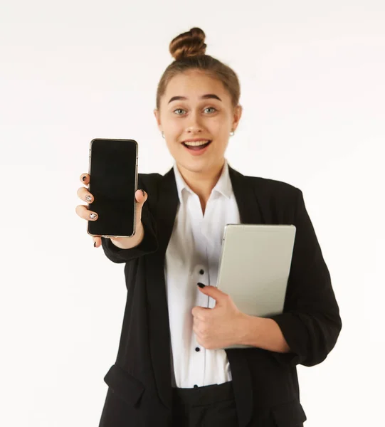 Młoda Dziewczyna Ubraniu Biurowym Trzyma Telefon Rękach Pokazuje Widzowi Podczas — Zdjęcie stockowe
