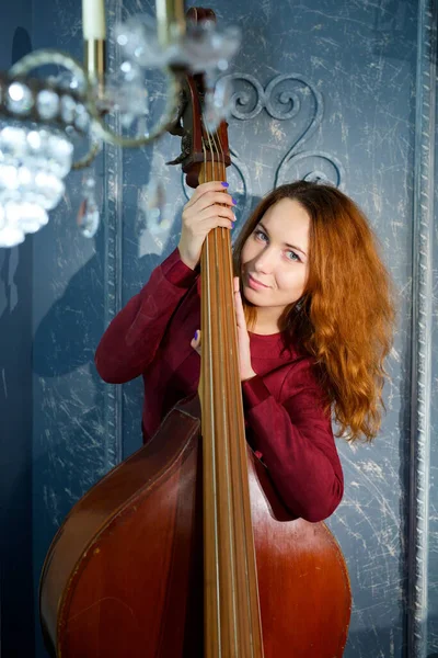 Flickan Den Röda Klänningen Står Studion Och Håller Ett Musikinstrument — Stockfoto