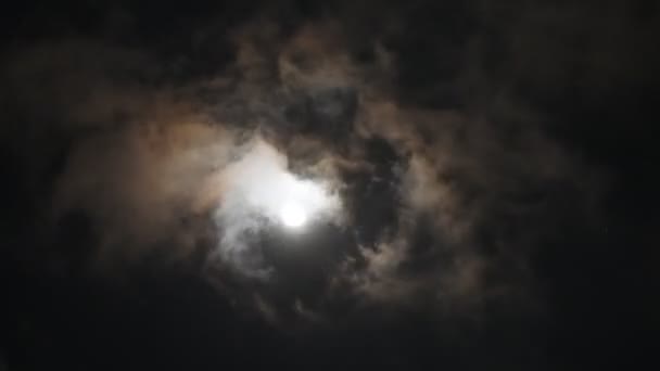 Moon rising behind swirling clouds — Stock Video