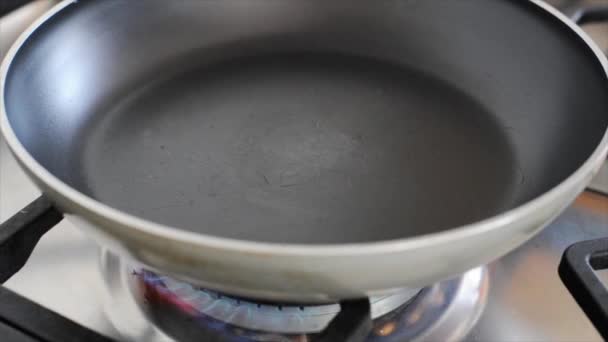 Наливание масла в сковороду — стоковое видео