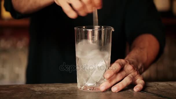 Bartender stirring ice cubes in glass — Stock Video