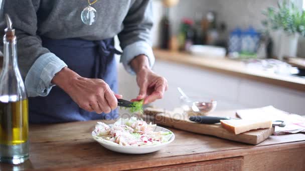 Vrouw Knippende venkel verlaat over salade — Stockvideo