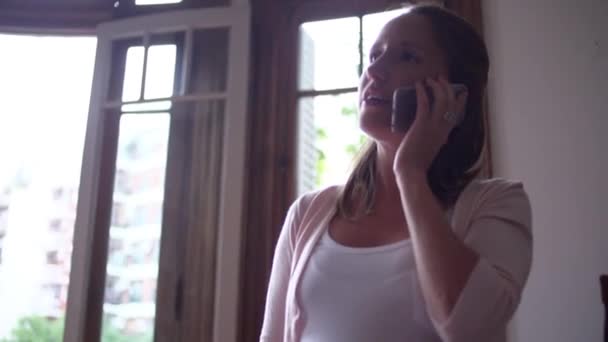 Беременная женщина разговаривает по мобильному телефону — стоковое видео