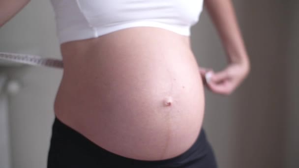 Femme enceinte mesurant son estomac — Video