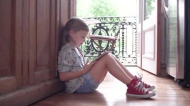 Küçük kız yere, oturma dijital tablet kullanma