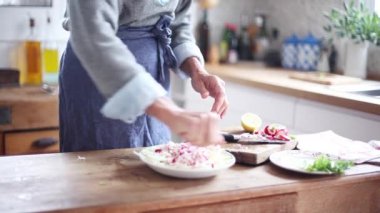 Kesilmiş sebzelerin üzerine limon sıkarak kadın