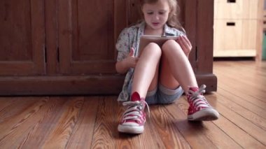 Katta oturan, dans ve dijital tablet vasıl bakarken şarkı küçük kız