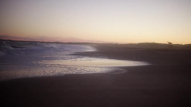 Kumsalda alacakaranlık sörf