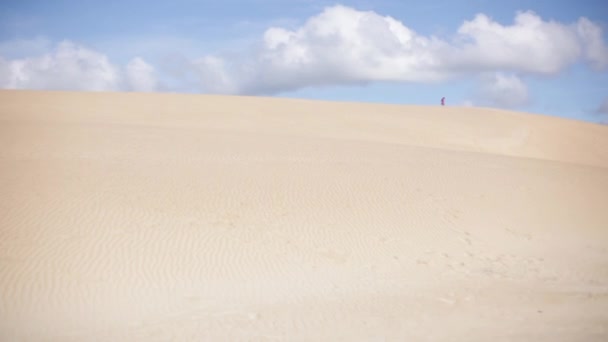 Persona che cammina lungo la cima di grandi dune di sabbia — Video Stock