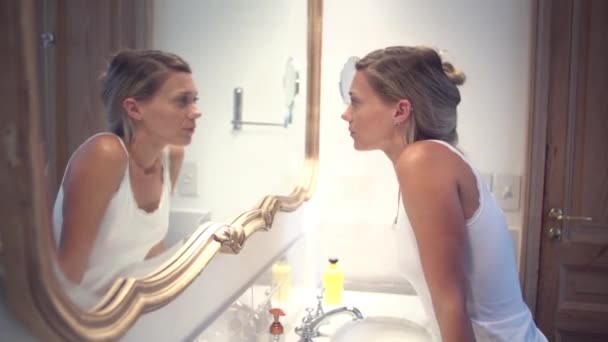 Donna che guarda il suo riflesso nello specchio del bagno — Video Stock