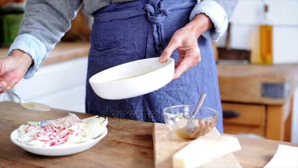 Frau löffelt Salatdressing auf geschnittenem Gemüse — Stockvideo