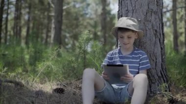Çocuk ormanda dijital tablet kullanma