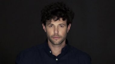 Parmağını dudağına sessizlik içinde tutan adam