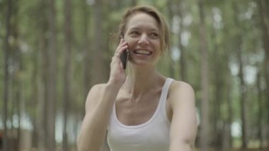 Olgun bir kadın cep telefonuyla konuşuyor.