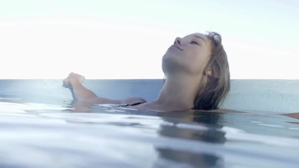 Woman relaxing in swimming pool — Stock Video