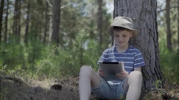 Pojke med digital tablett i skogen — Stockvideo