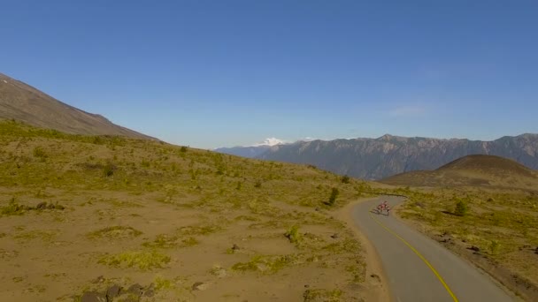 Cyclists and a vehicle traveling along a winding road near Osorno, Los Lagos Region, Chile — Stock Video