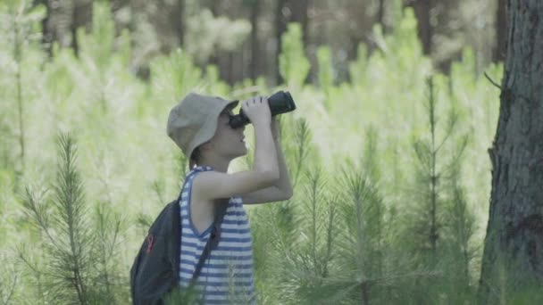 Pojke som utforskar i skogen med kikaren — Stockvideo