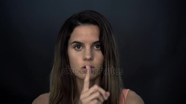 Frau hält schweigend Finger an Lippen — Stockvideo