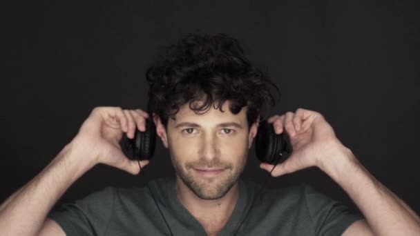 Hombre poniéndose auriculares y escuchando música — Vídeos de Stock