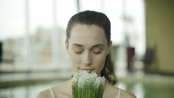 Νεαρή γυναίκα που μυρίζουν φρέσκα λουλούδια — Αρχείο Βίντεο