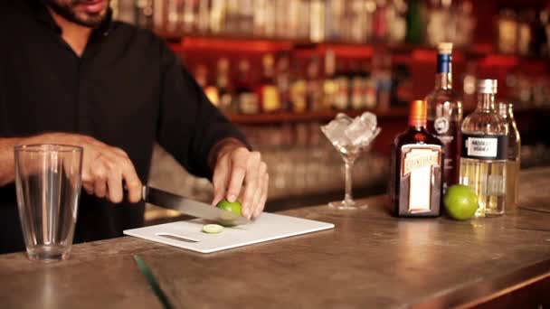 Bartender slicing lime for cocktail — Stock Video